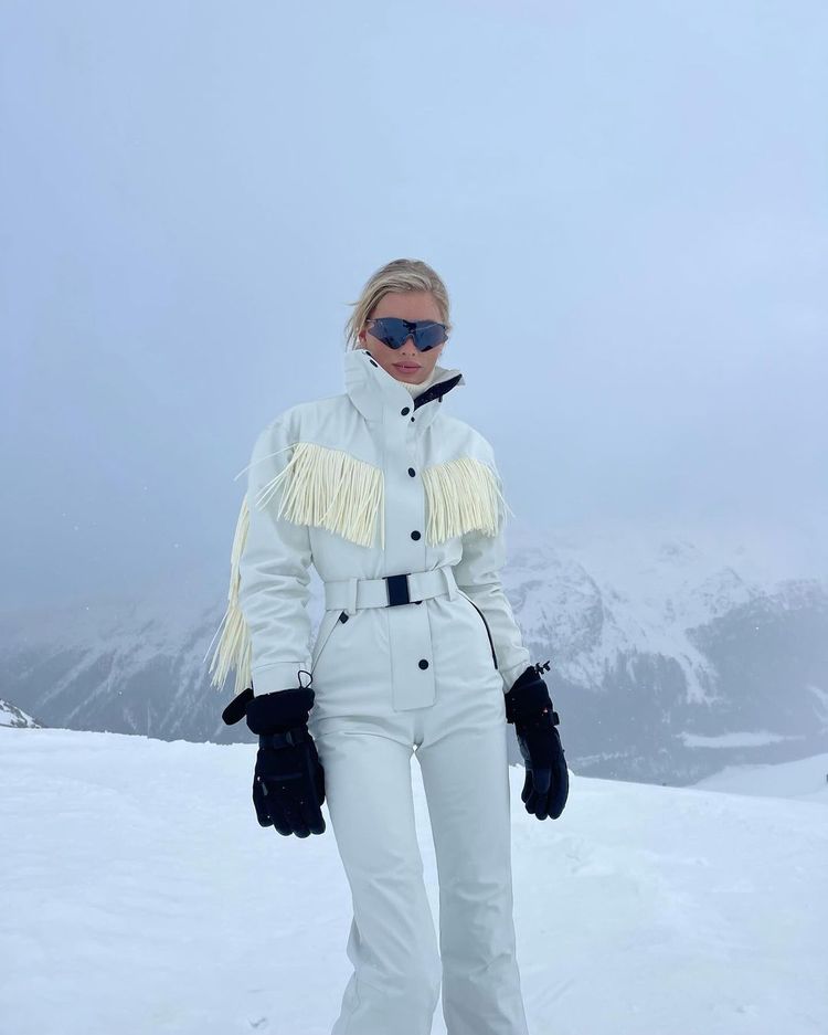 Elsa Hosk poses in a fringed, belted ski suit with mittens and tinted shades in St Moritz
