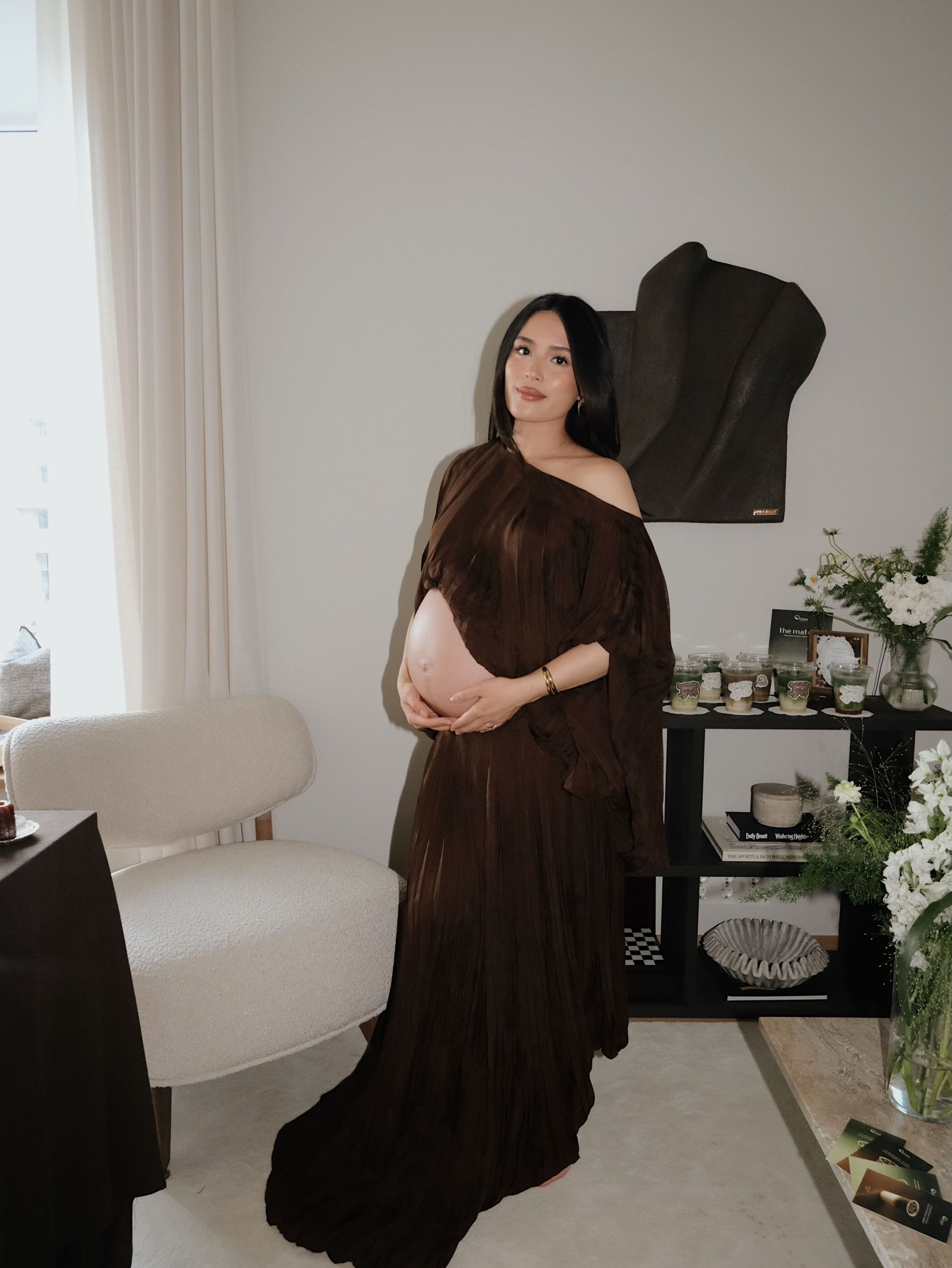 Tsutsumi wears a brown belly bearing dress