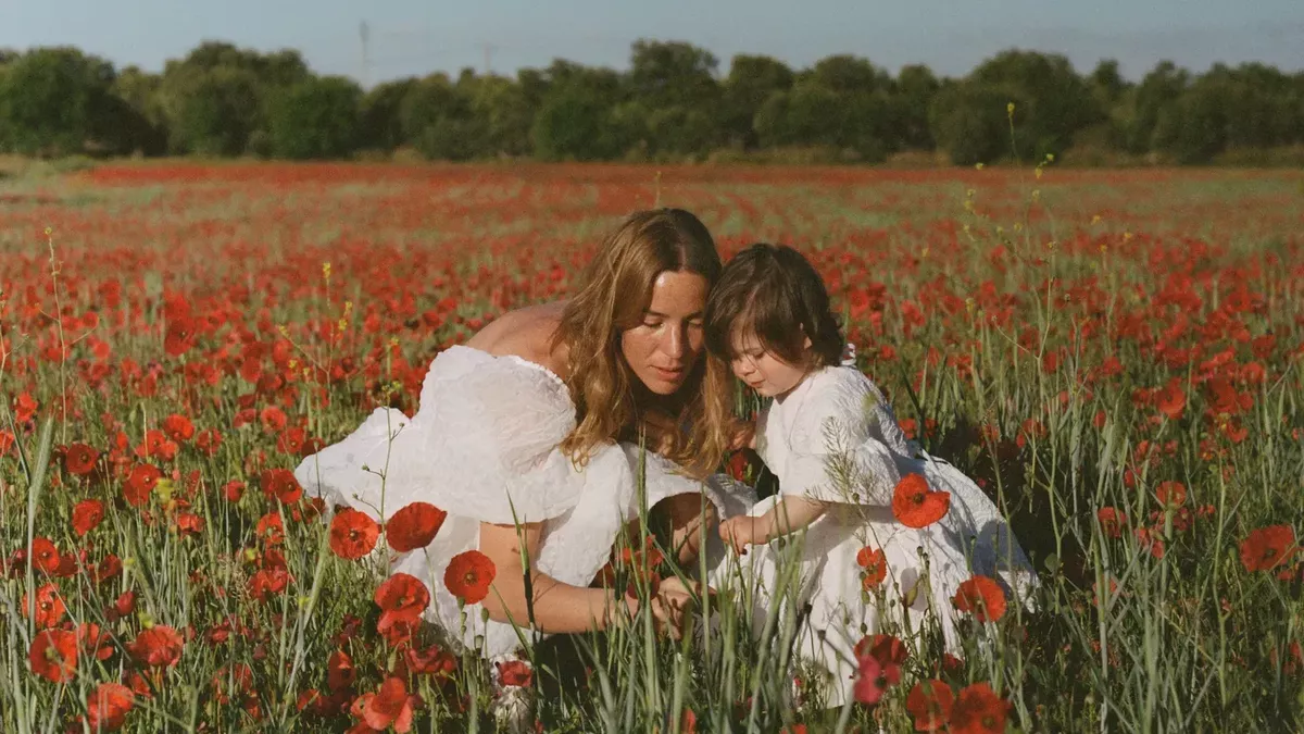 A mother and her child pose in a poppy field