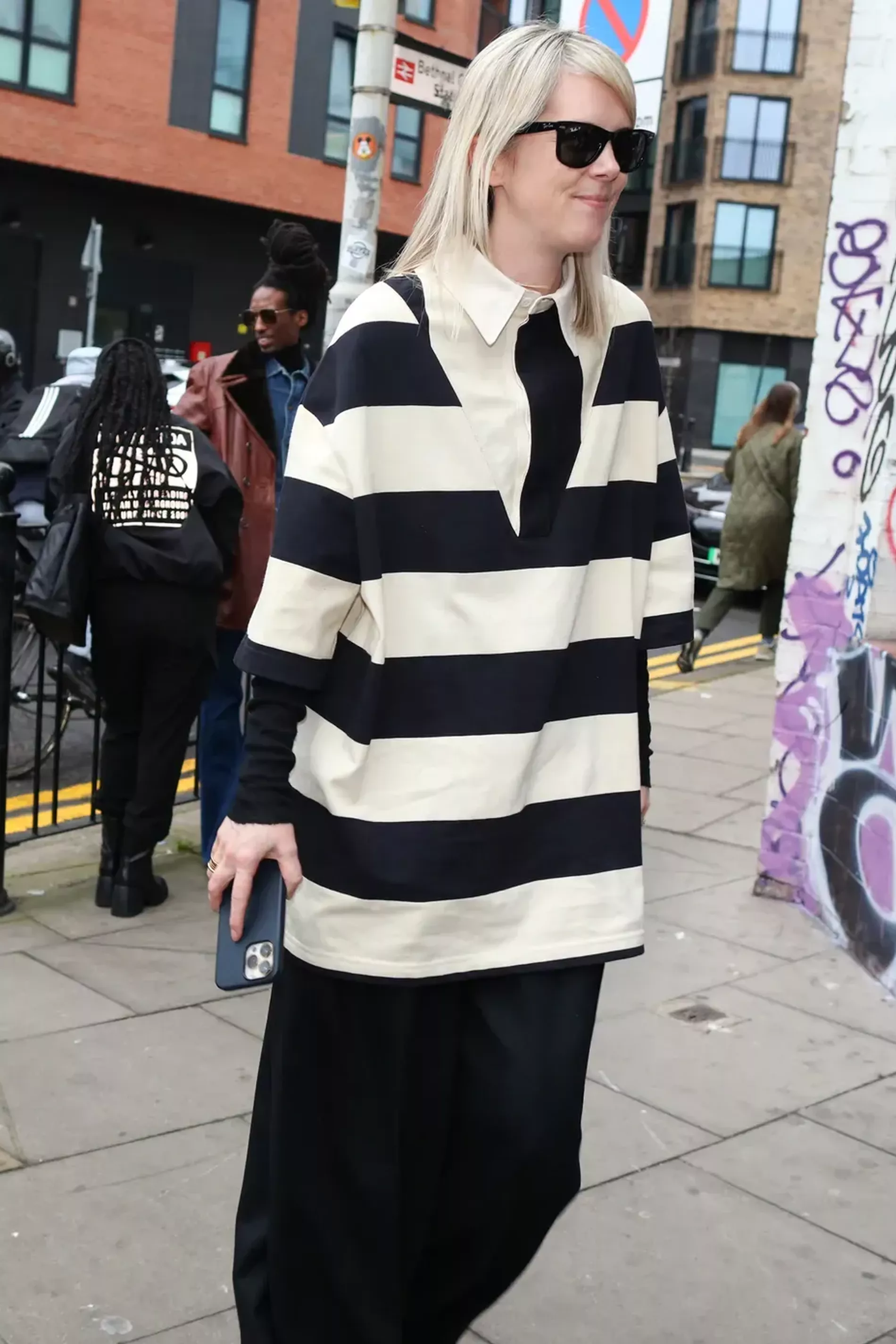 London fashion week guest wears striped oversized shirt 