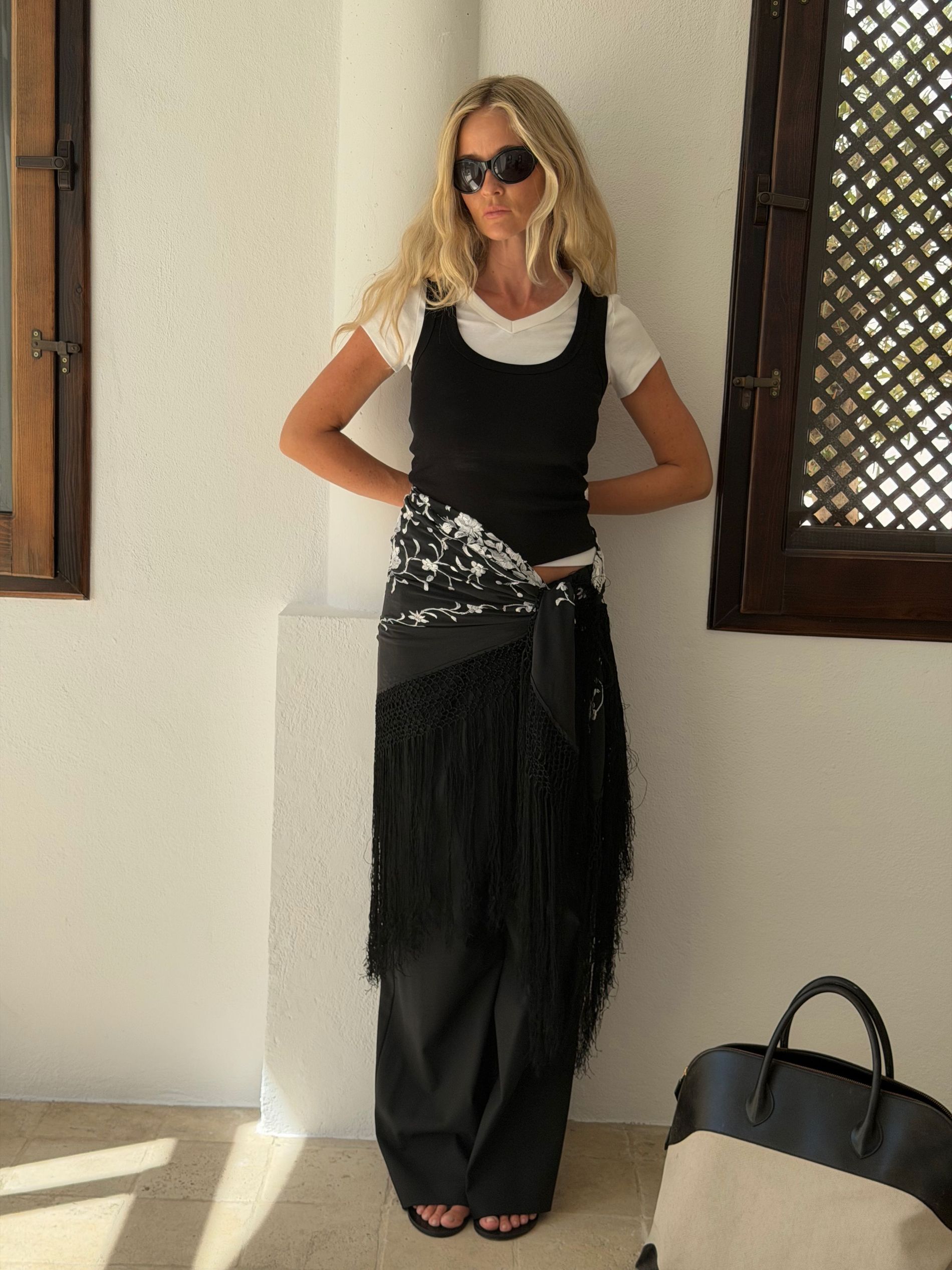 Josefin wears black trousers, emboirdered scarf belt, black tank and white tee