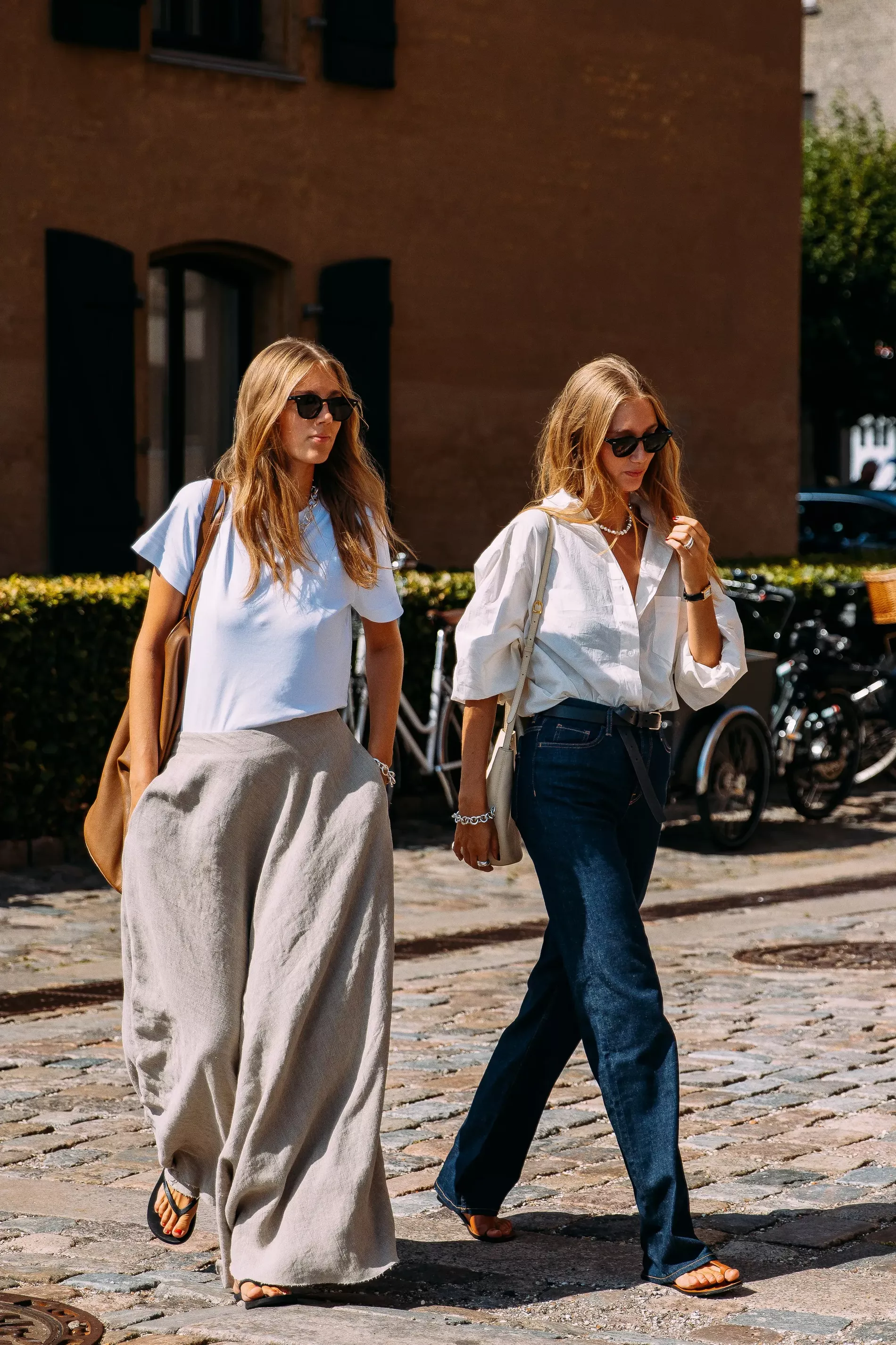 Copenhagen Fashion Week guests wear breezy white tops with jeans and beige pants 