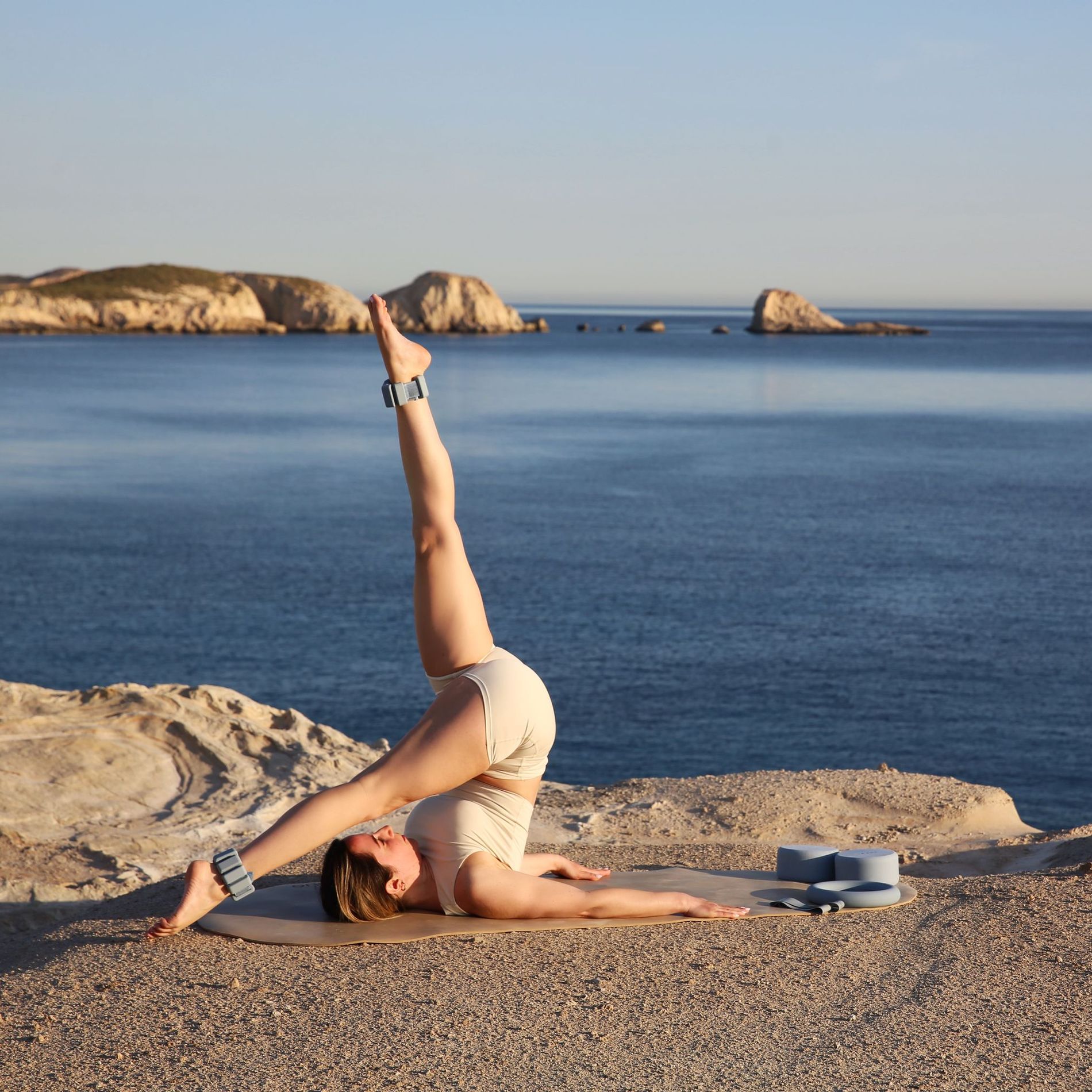 woman workoing out with blue onyx gear against ocean background