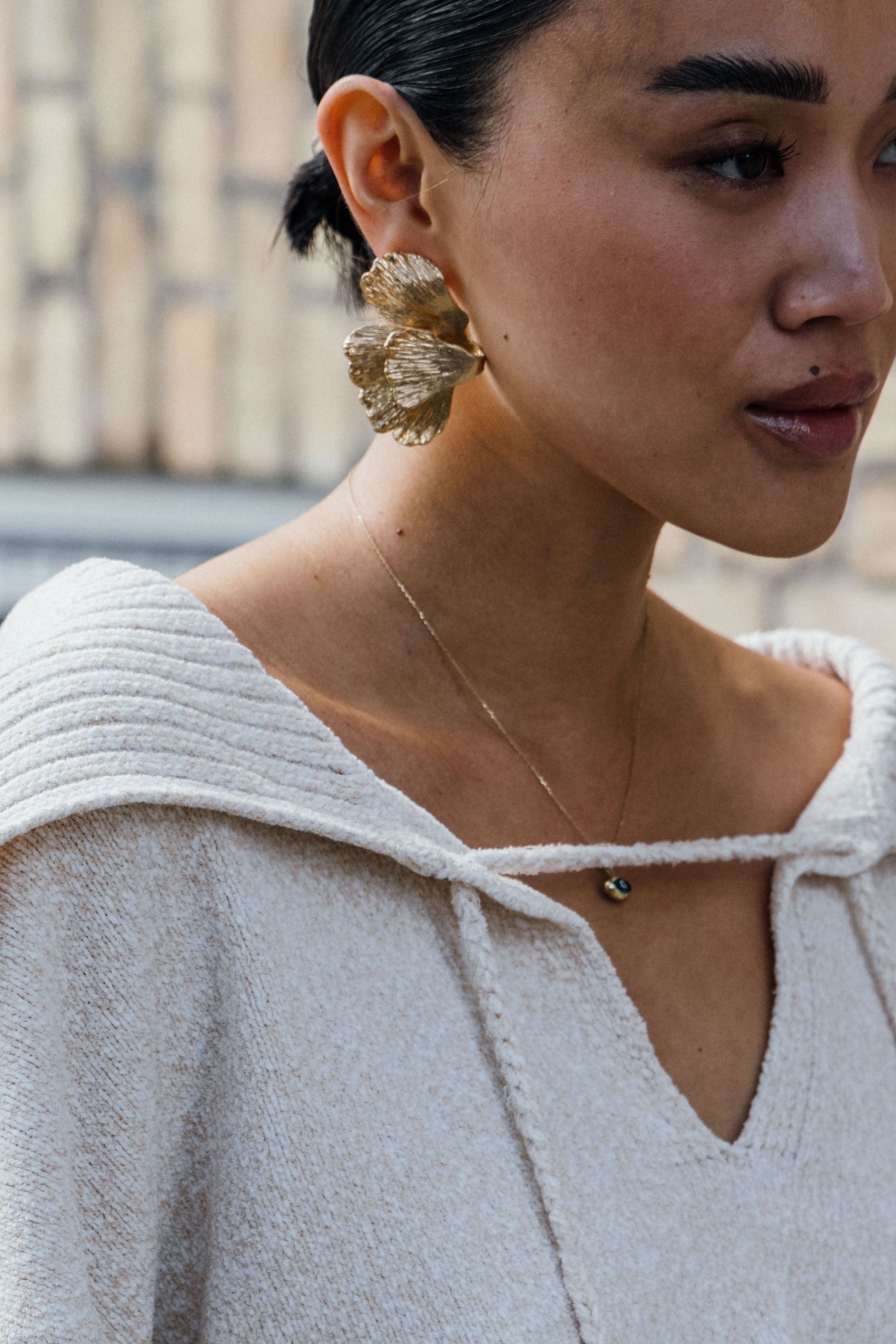 Guest wears a pair of gold statement earrings to Copenhagen Fashion Week SS24