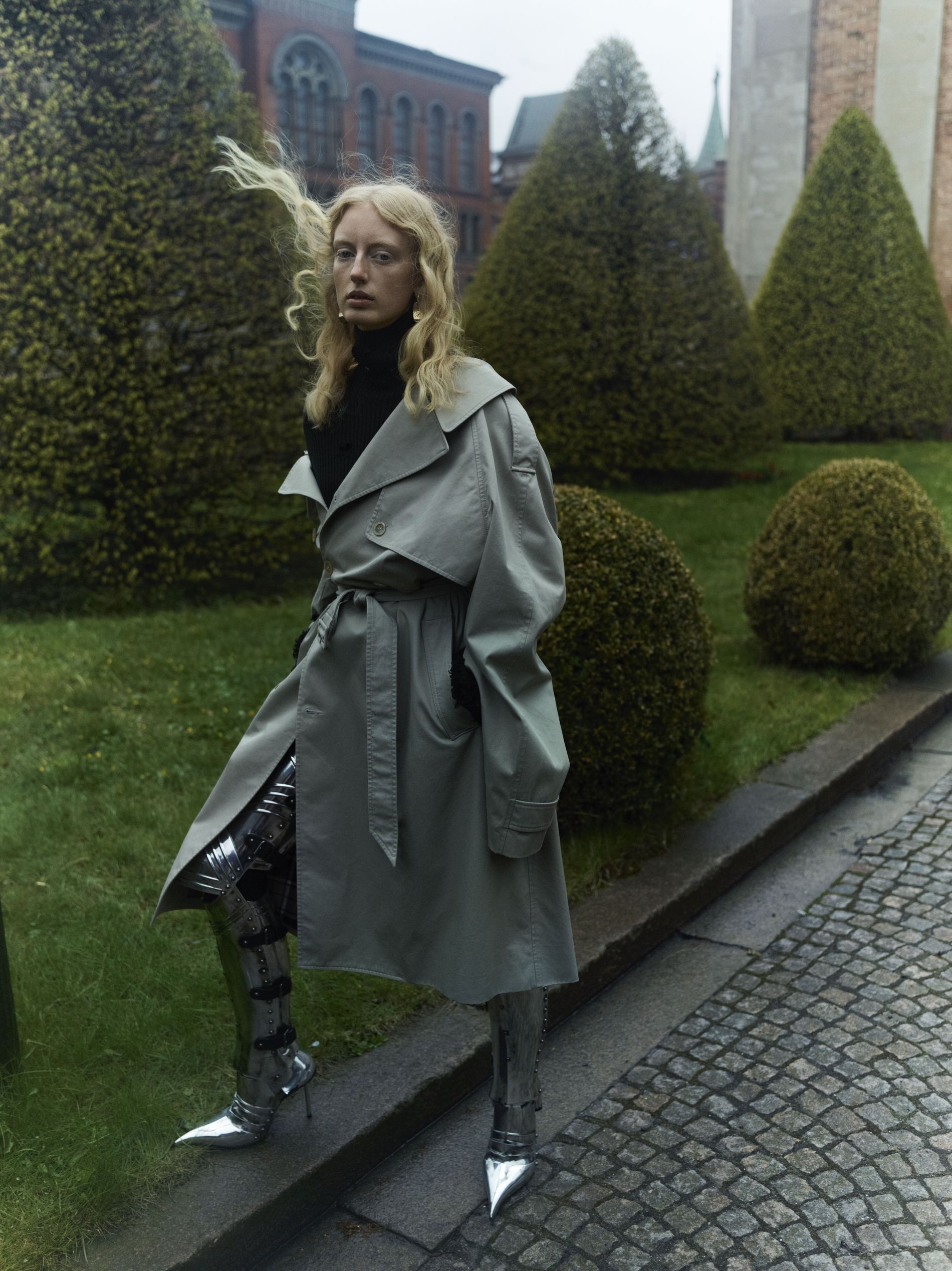 Twill trench coat, €2,390, Turtleneck, €1,090, Earrings, €495, Chevalier over-the-knee boots, €5,550. All Balenciaga.