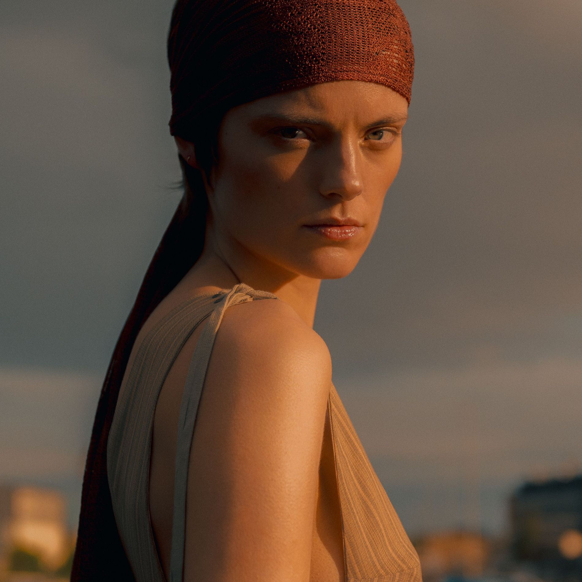 A woman wearing a headscarf facing the camera 