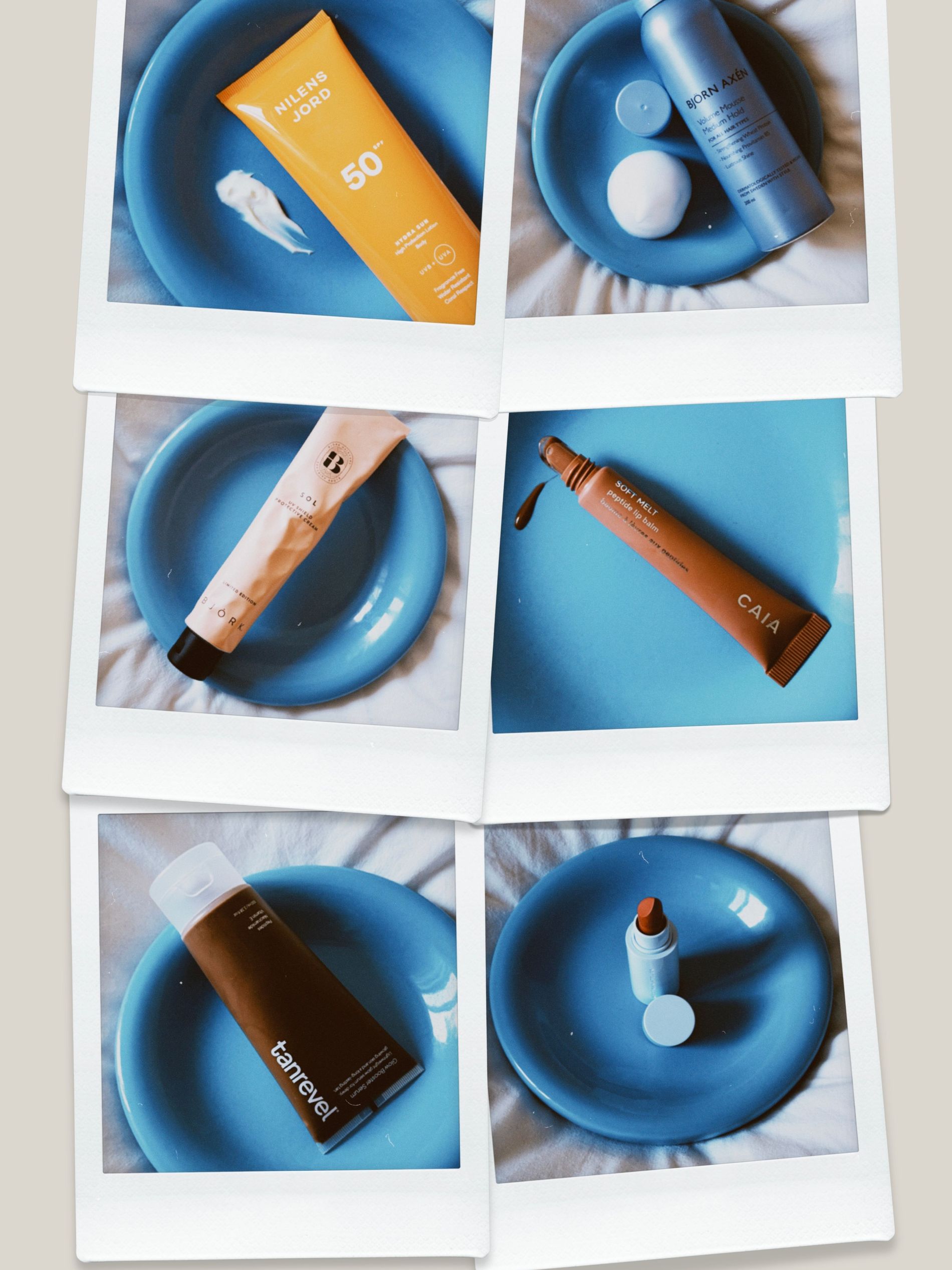 Polaroid photos of Nilen's Jord Hydra Sun SPF50 lotion, Björn Axen's volume mousse, Caia's soft melt lip treatment, Tanrevel's bronzing serum and Westman Atelier's tinted lip balm on a chubby blue plat on white sheets