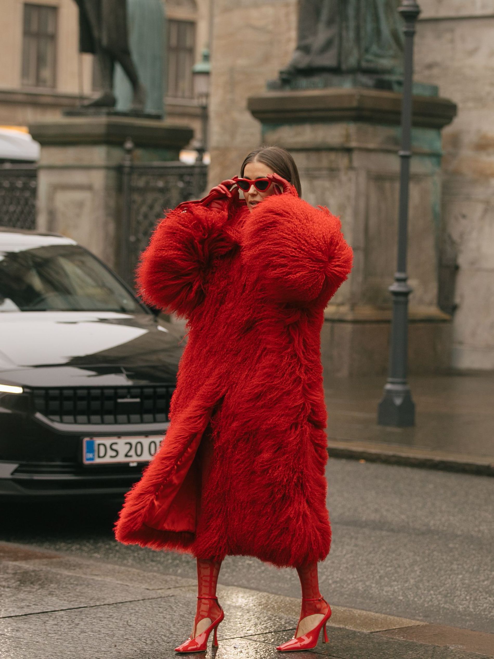 A guest at Copenhagen Fashion Week wears an all-red outfit, featuring s red fur coat