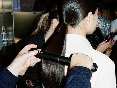 A model gets her ponytail straightened backstage at Stine Goya's AW24 Copenhagen Fashion Week runway show