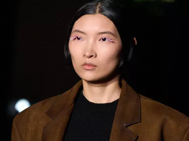 A model with pink pastel lashes walks Prada's autumn/winter 2023 show