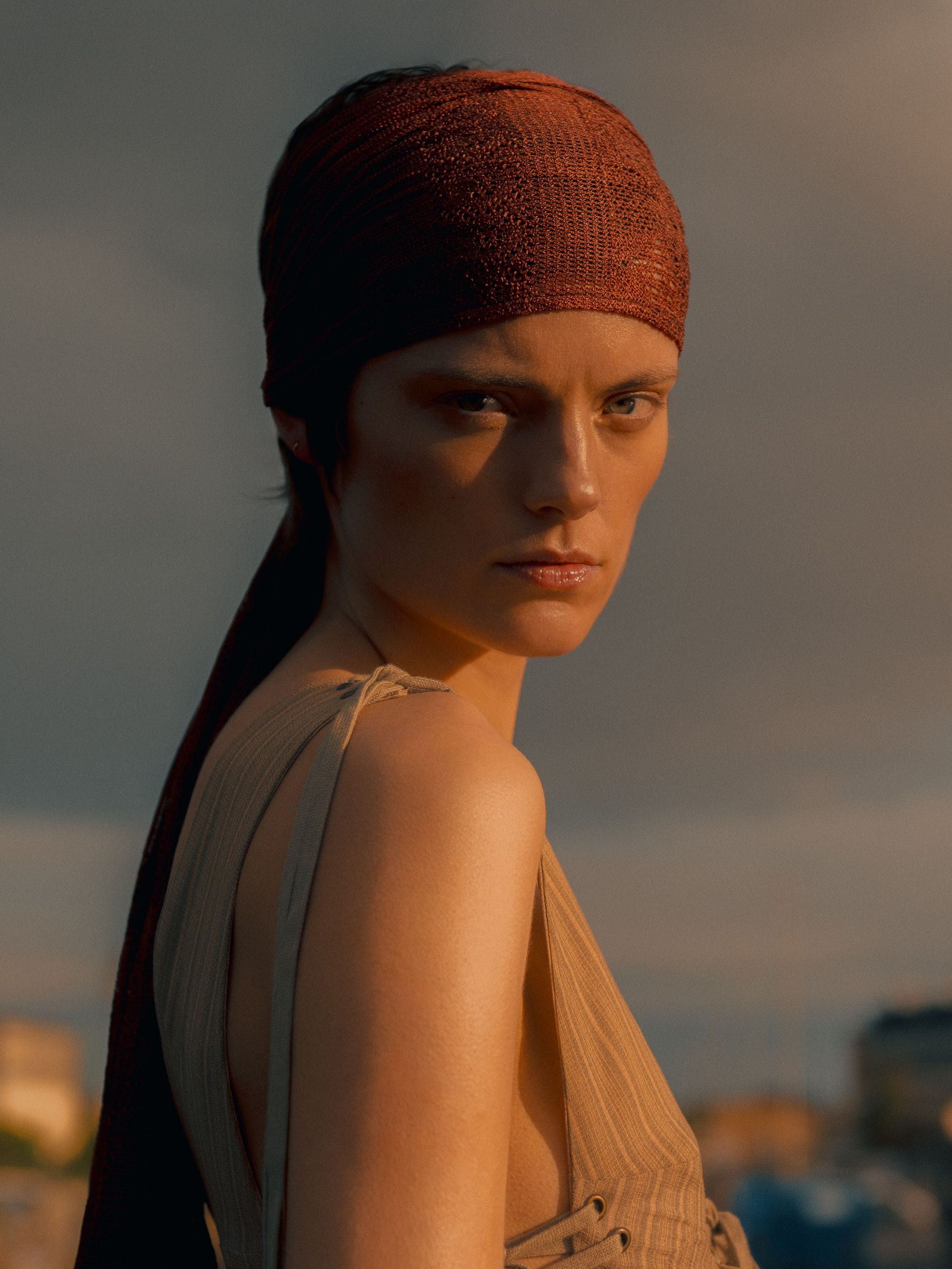 A woman wearing a headscarf facing the camera 