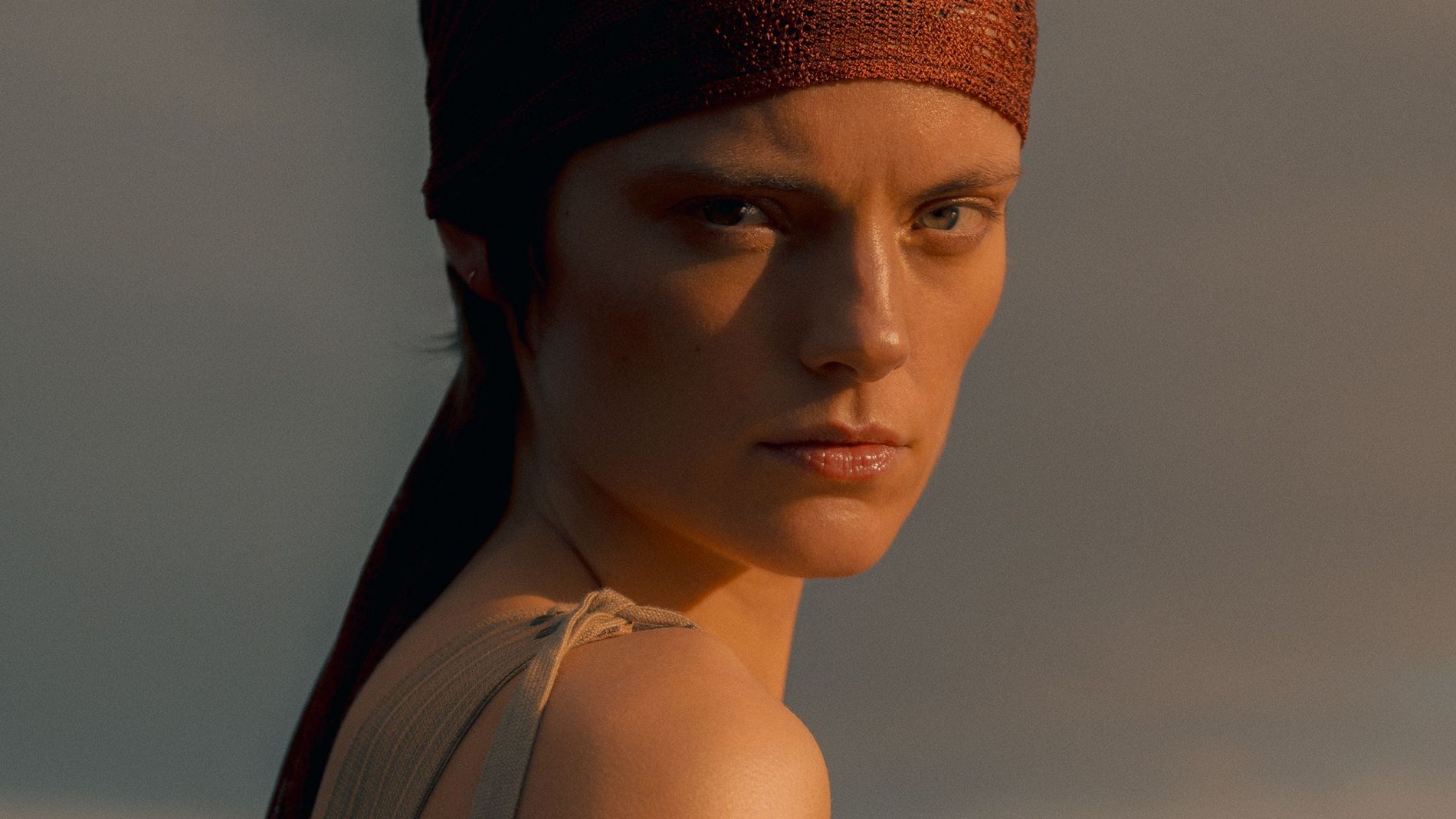 A woman wearing a headscarf facing the camera 