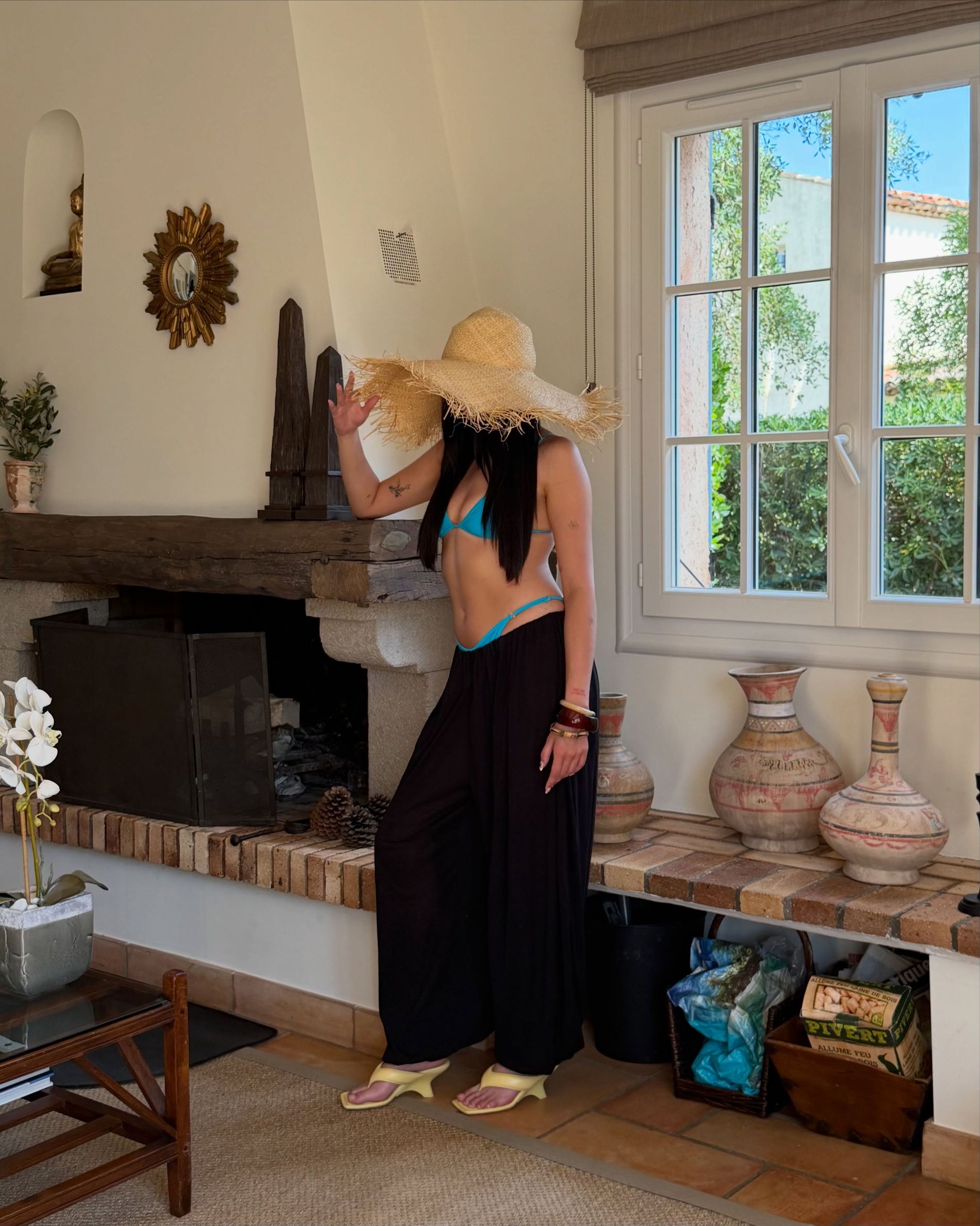 Maya Nilsen wears a blue bikini from Bared, straw hat, black trousers and butter yellow heels