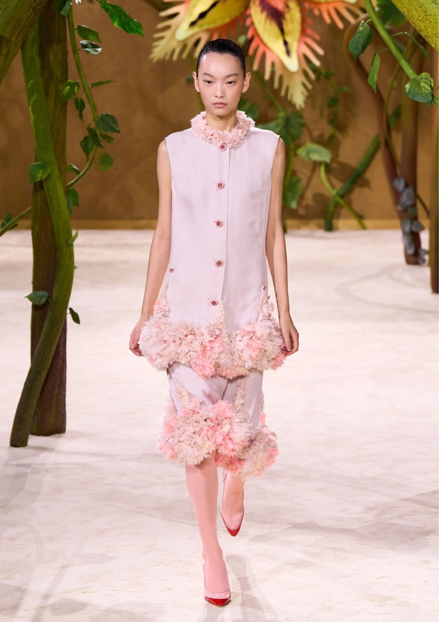 Sleeveless longline tunic with floral appliqué trim, matching mid skirt with floral appliqué detailing, and pointed-toe pumps