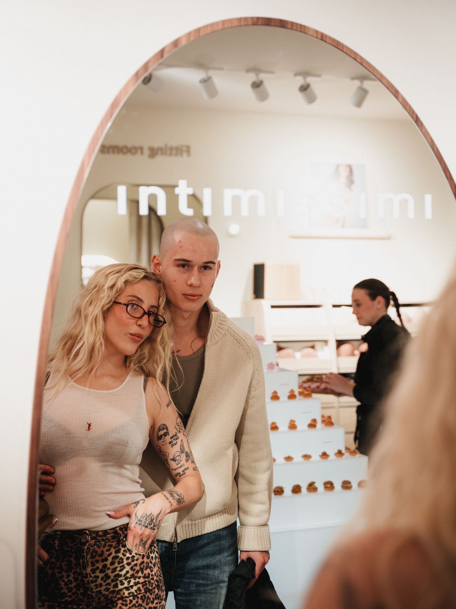 Peg Parnevik and Melvin Carrere at the intimissimi X Vogue Scandinavia event dressed in beige neutrals posing in a mirror