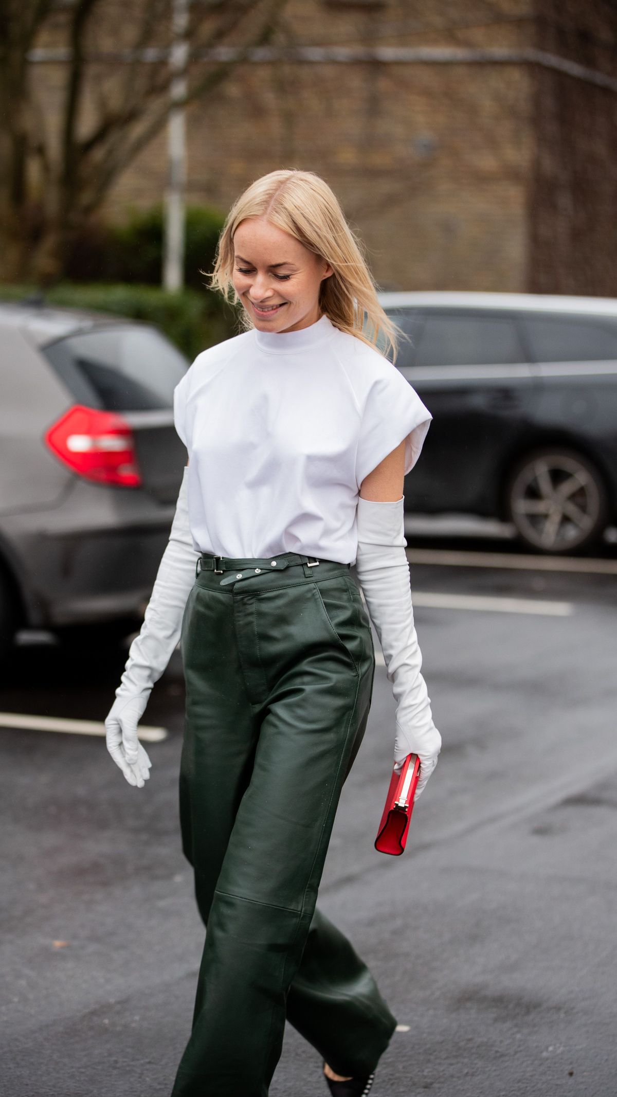 Julie Pelipas wears black jacket, wide leg denim jeans outside