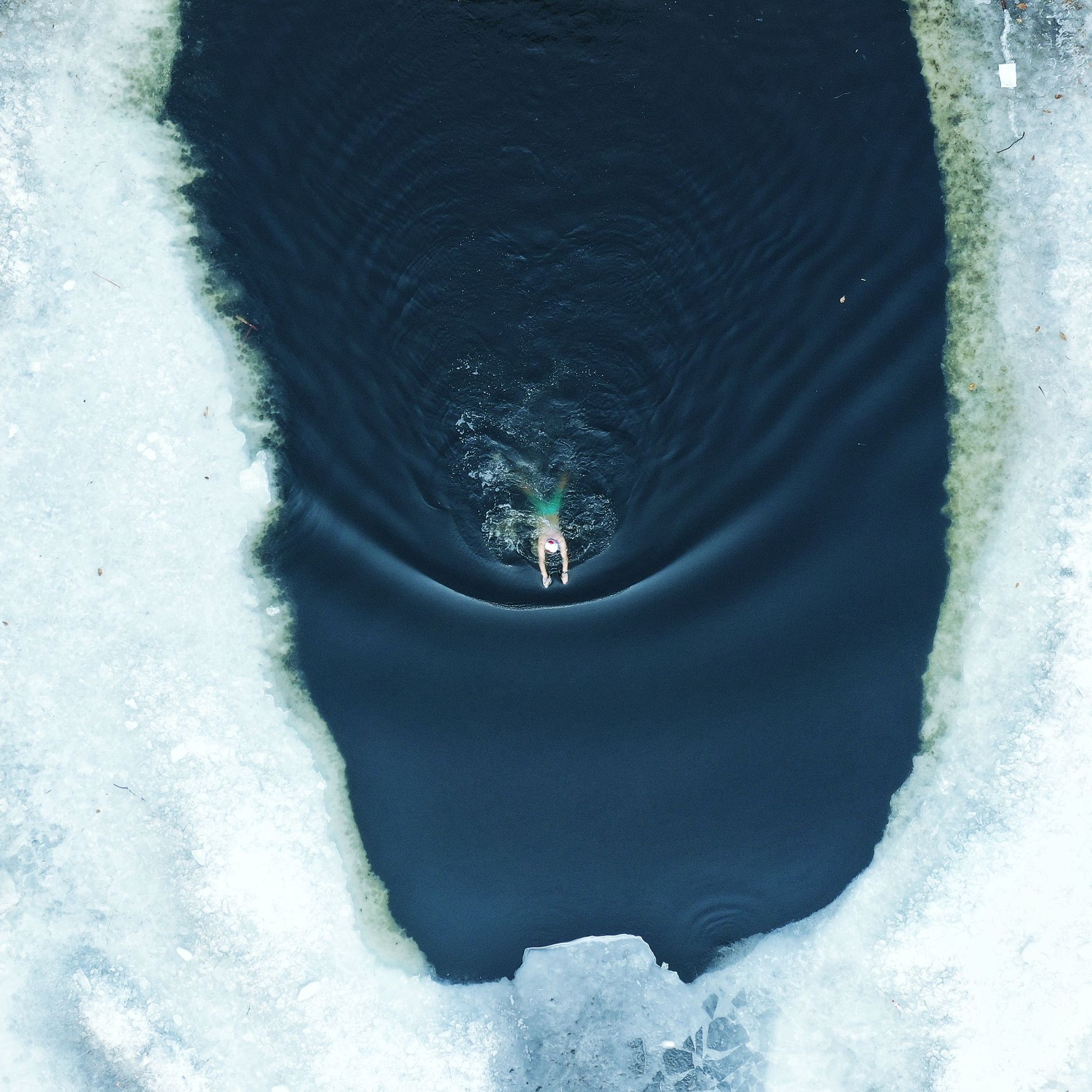 Woman swimming in frozen lake
