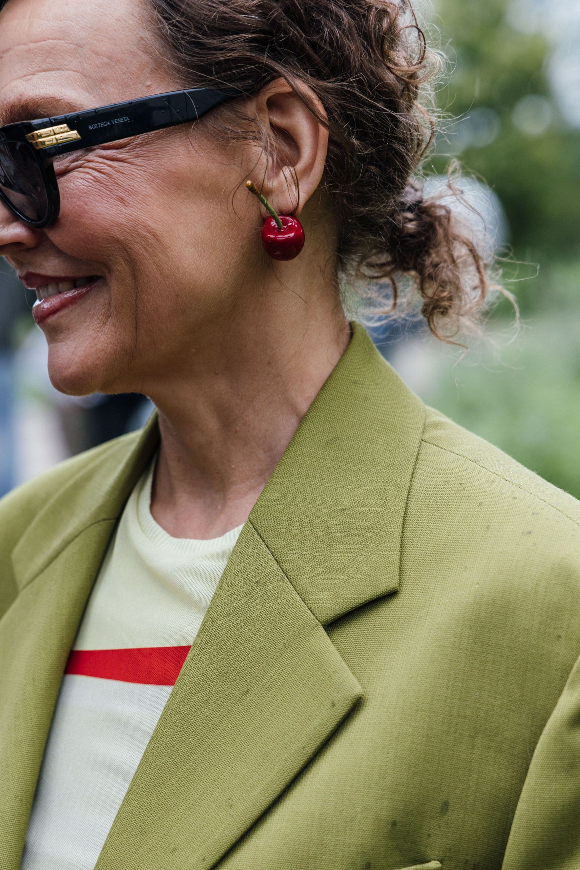 Guest wears a pair of cherry statement earrings to Copenhagen Fashion Week SS24