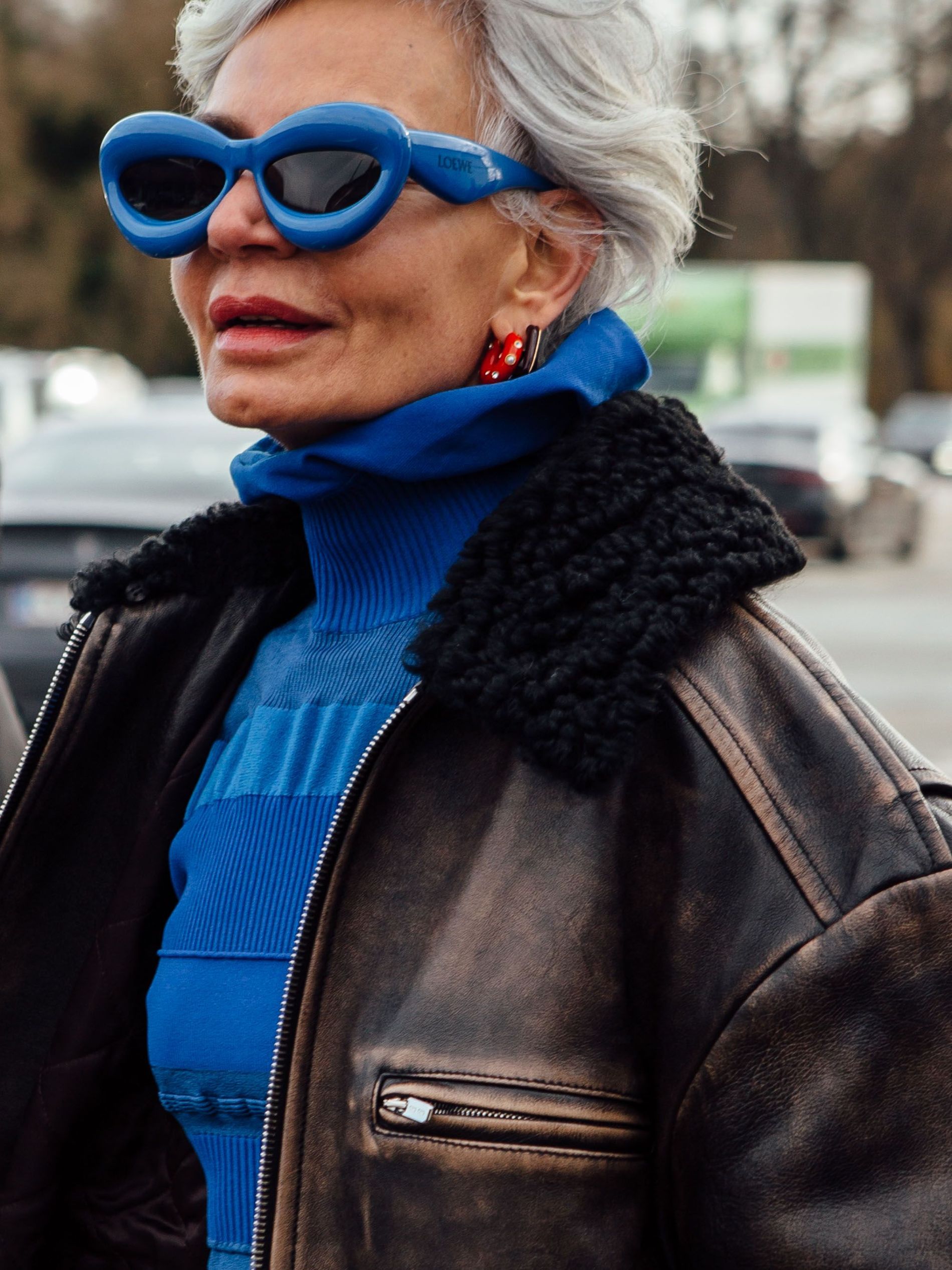 Guest wears blur Loewe bubble sunglasses with matching knitted top and an aviator jacket