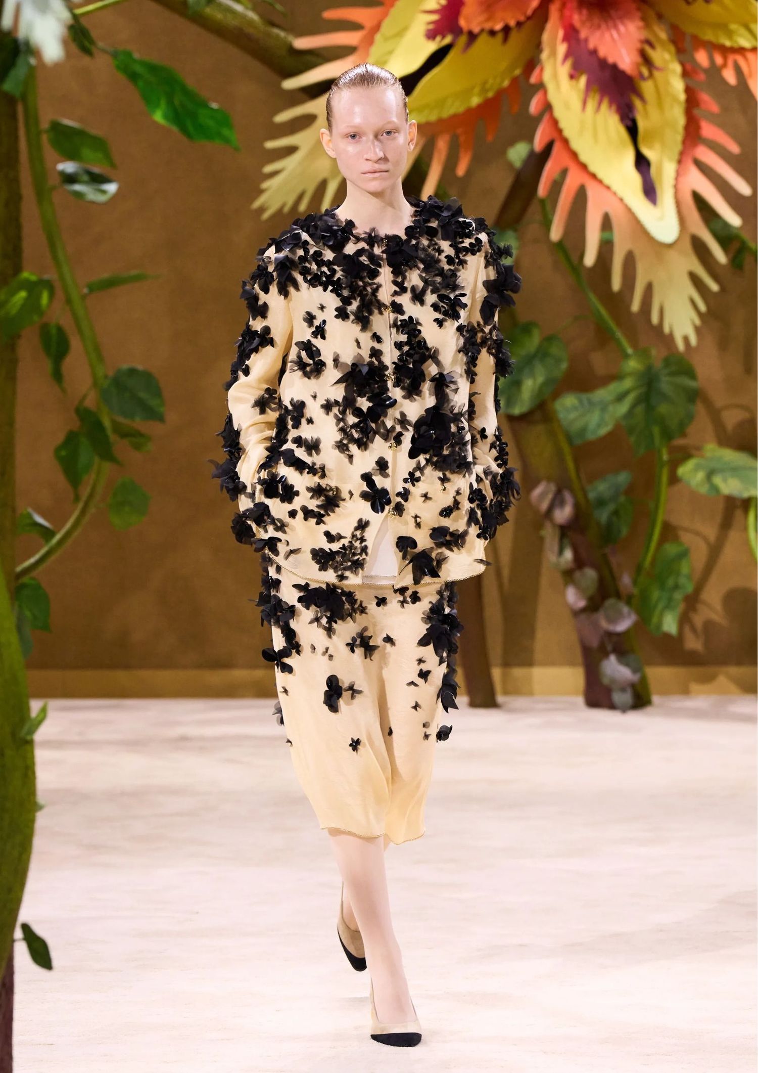 Cream long-sleeved matching set consisting of a skirt and a jacket with black floral appliqués.