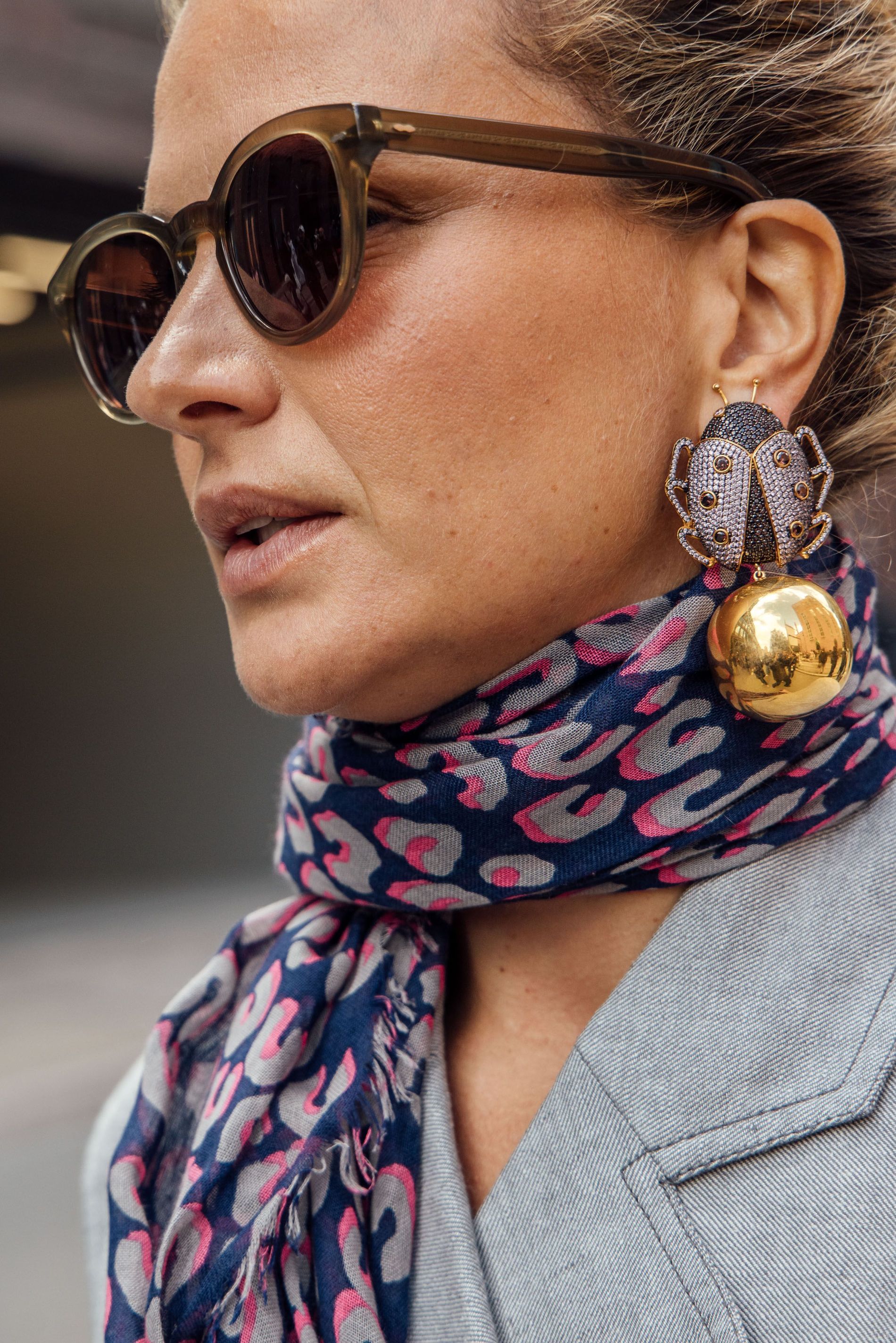 Guest wears a pair of lady bug statement earrings to Copenhagen Fashion Week SS24