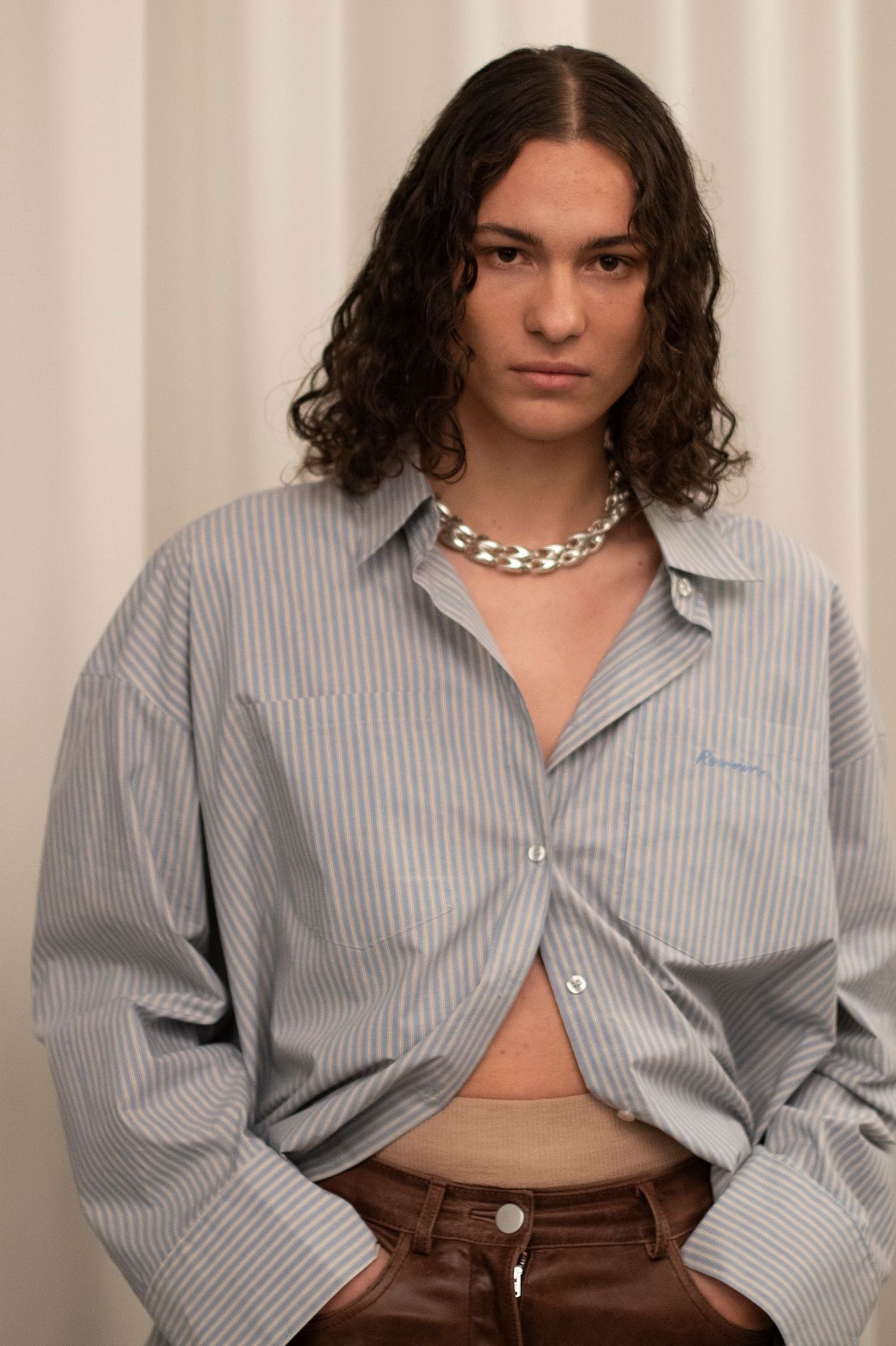 Model with tousled salt water waves poses backstage at Remain AW23