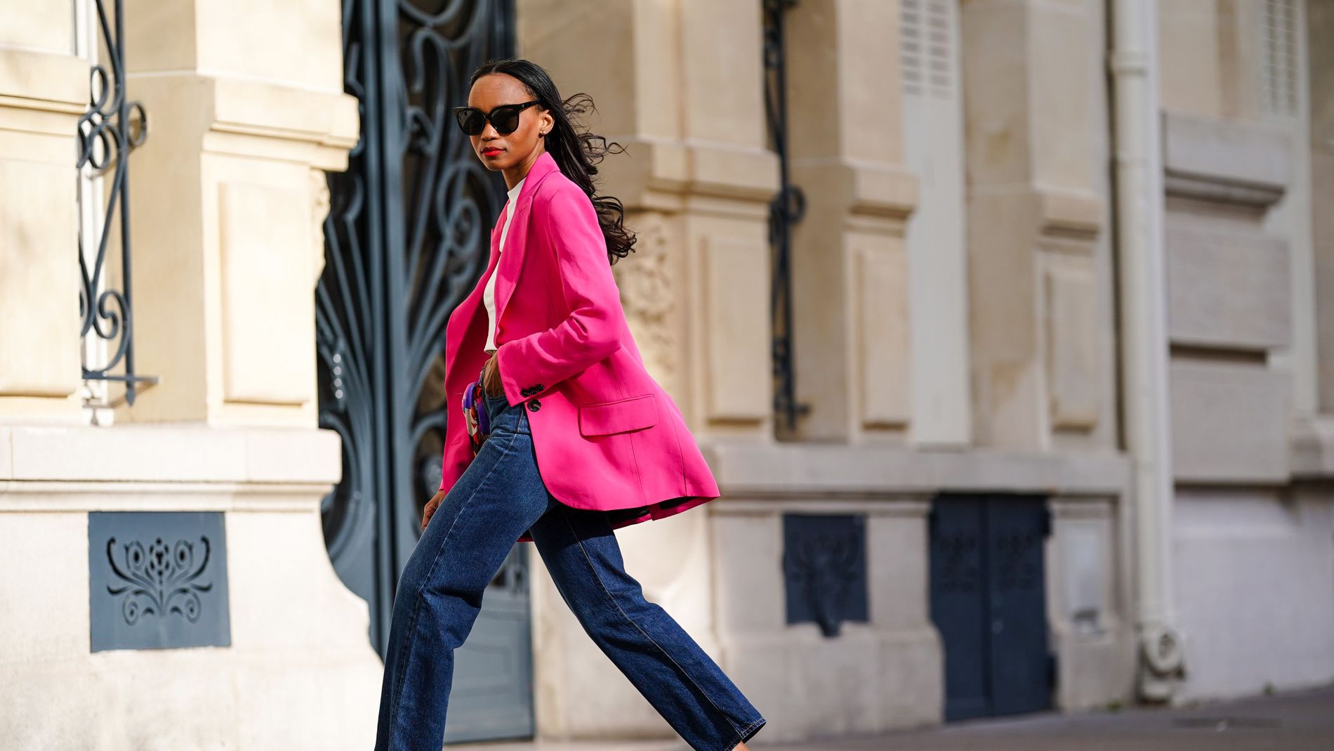 Woman wearing bright pink suit jacket, a trend to shop for spring/summer 2022